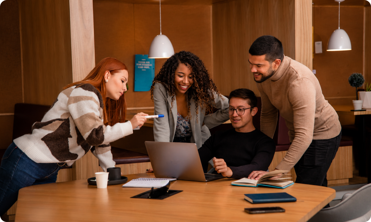 Team collaborating around a laptop